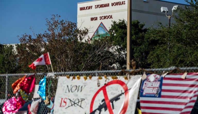 Signs line a fence outside at Marjory Stoneman Douglas High School. 