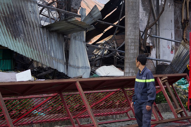 A man looks at the damaged building of Taiwanese bicycle factory Tan Than in Di An Town, Binh Duong Province, Vietnam, Wednesday, May 14, 2014. Mobs burned and looted scores of foreign-owned factories in Vietnam following a large protest by workers against China's recent placement of an oil rig in disputed Southeast Asian waters, officials said Wednesday. (AP Photo/Jeff Nesmith)