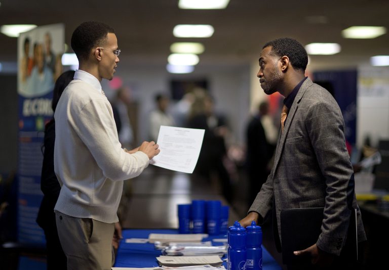 Retired U.S. Air Force Master Sgt. Thomas Gipson, right, has his resume looked over by Ralph Brown, a management and program analyst with the Centers for Disease Control and Prevention, during a job fair. (AP/David Goldman)