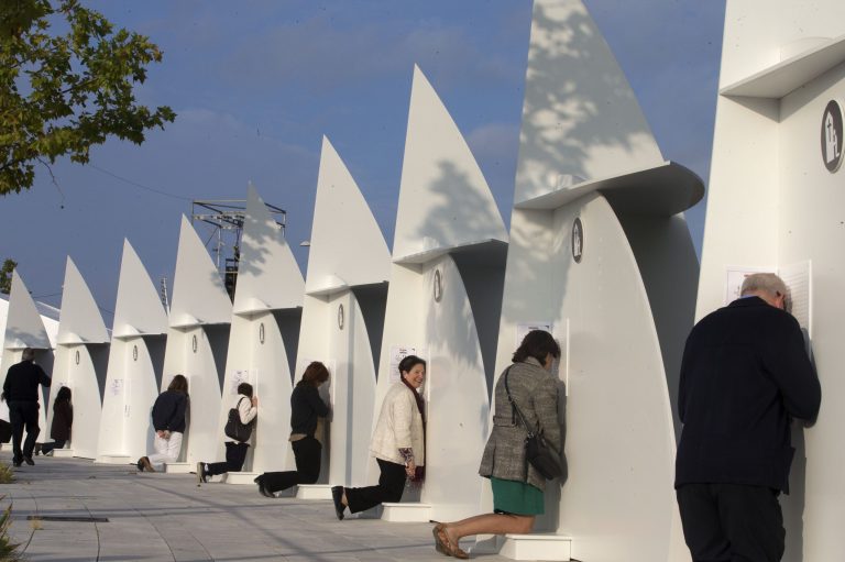 People kneel at confessional boxes before the start of a beatification ceremony in Madrid, Spain, Saturday, Sept. 27, 2014.  More than 100,000 Catholics from around the world are expected to attend the open air beatification ceremony Saturday of Opus Dei Bishop Alvaro del Portillo, the 2nd most important figure in the order after founder Jose Maria Escriva. (AP Photo/Paul White)