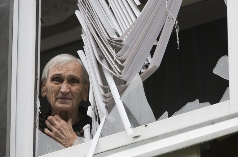 A woman, name not given, looks out from her damaged house in the city of Slovyansk, Donetsk Region, eastern Ukraine Monday July 7, 2014. Ukraine's president Petro Poroshenko has called the capture of the Pro-Russian separatist stronghold of Slovyansk a 