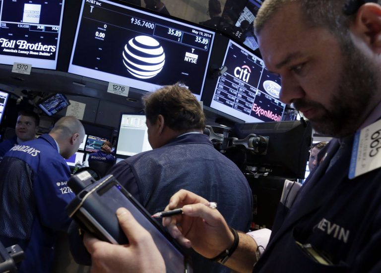 Traders gather at the post that handles AT&T on the floor of the New York Stock Exchange Monday, May 19, 2014. Priming itself for the age of Internet-delivered video, AT&T Inc. said it would buy DirecTV for $48.5 billion in cash and stock, or $95 per share. (AP Photo/Richard Drew)