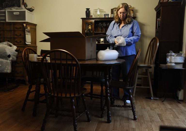 In this Dec. 23 photo, Leslie Lynch packs up belongings in her dining room in Glastonbury, Conn. Lynch, who lost her job last year, is moving out of her home of 21 years because she can no longer afford the mortgage payments. (AP Photo/Jessica Hill)