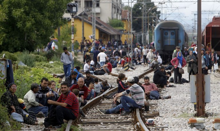 Migrants sit on the tracks at the railway station in the southern Macedonia's town of Gevgelija, after breaking through the police blockade on the border with Greece, on Saturday, Aug. 22, 2015. (AP Photo/Boris Grdanoski)