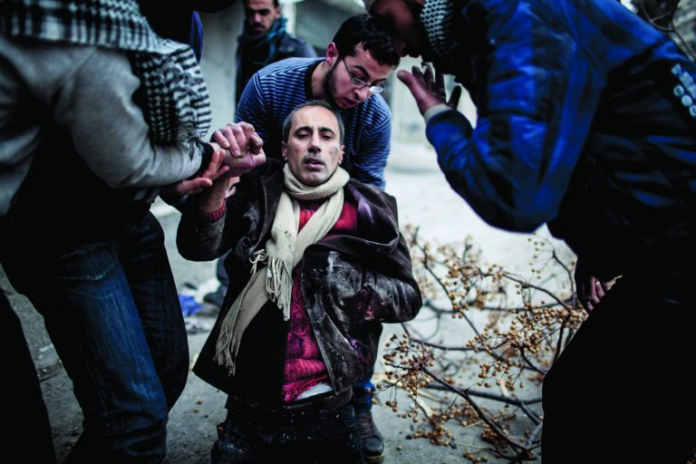 Men help a wounded civilian after a mortar attack in the Saif al-Dawlah neighborhood of Aleppo, Syria, Sunday, Jan. 13, 2013. The revolution against the Syrian regime started in March 2011 with peaceful protests but morphed into a civil war that has killed more than 60,000 people, according to a recent United Nations estimate. (AP Photo/Andoni Lubaki)