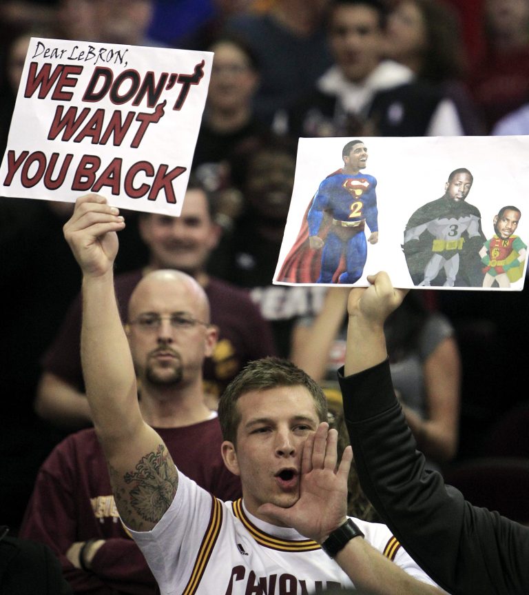FILE - In this Feb. 17, 2012, file photo, a Cleveland Cavaliers holds a sign and yells as Miami Heat's LeBron James is introduced before andanNBA basketball game against Cavaliers in Cleveland. James told Sports Illustrated on Friday, July 11, 2014, he is leaving the Miami Heat to go back to the Cleveland Cavaliers. (AP Photo/Tony Dejak, File)