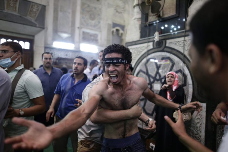 Egyptians mourn over the bodies of their relatives in the Al-Fath mosque in Cairo on Friday. (AP Photo/Hassan Ammar)