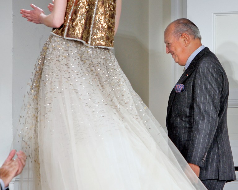FILE - In this Feb. 4, 2008, file photo, designer Oscar de la Renta is applauded after the presentation of his fall 2008 collection during Fashion Week in New York. The designer, who died Monday, Oct. 20, 2014, at 82, shaped American couture half a century ago when it emerged as a serious rival to European fashion designers. (AP Photo/Richard Drew, File)
