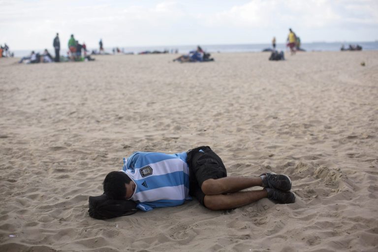 An Argentina soccer fan sleeps on Copacabana beach the morning after his team was defeated by Germany at the World Cup final, in Rio de Janeiro, Brazil, Monday, July 14, 2014. (AP Photo/Rodrigo Abd)