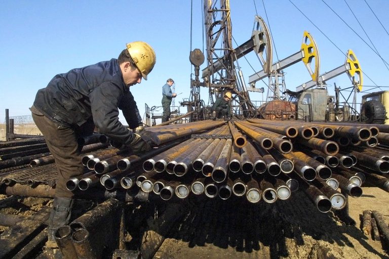 Workers repair an oil well owned by the Yukos company April 24, 2002 in Nefteyugansk, Siberia. (Photo by Oleg Nikishin/Getty Images)