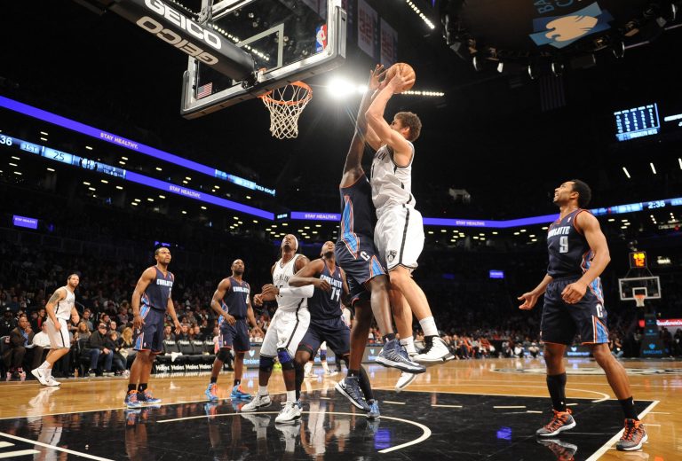   Brooklyn Nets' Brook Lopez (11) shoots over Charlotte Bobcats' DeSagana Diop (2) in the first half of an NBA basketball game on Friday, Dec., 28, 2012 at Barclays Center in New York. (AP Photo/Kathy Kmonicek)  