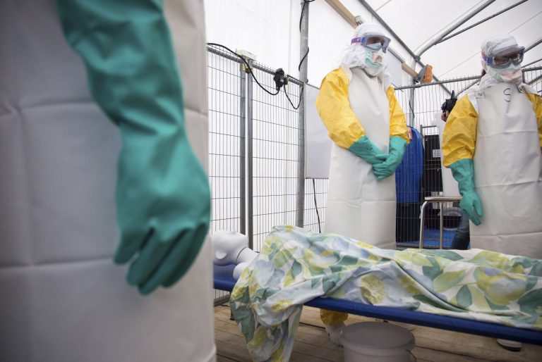 During a training session participants listen as they stand over a mannequin on a stretcher during a training course to instruct non-governmental organisation (NGO) workers and doctors on how to deal with the Ebola virus in Brussels on Tuesday, Aug. 26, 2014. The course, provided by Doctors Without Borders, trains volunteer and medical personnel on precautions to take when entering a zone that contains the Ebola virus.(AP Photo/Olivier Matthys)