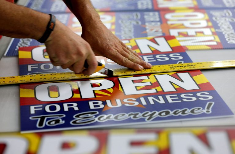 A sign company employee cuts a sheet of anti-Senate Bill 1062 signs in Phoenix, Ariz., on Wednesday. (AP Photo/Matt York, File)