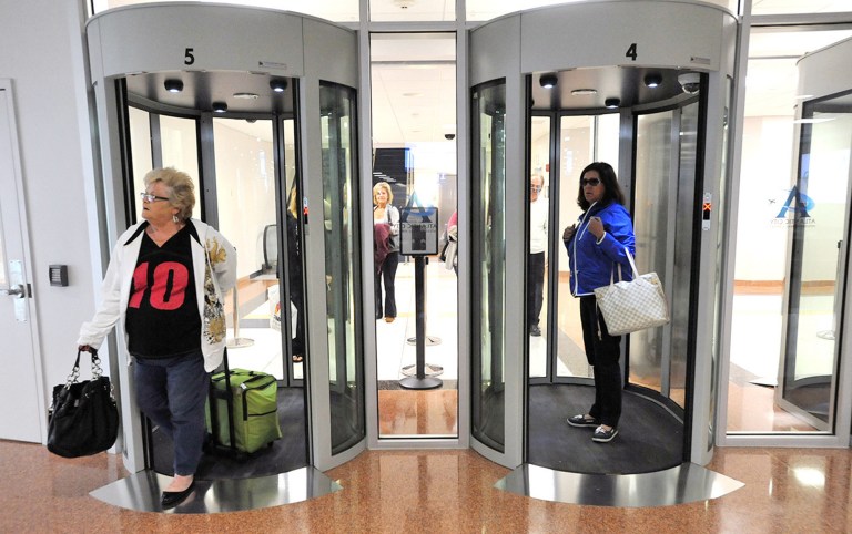 FILE - In this Nov. 26, 2012 file photo, passengers walk through security portals at the Atlantic City International Airport in Egg Harbor Township, N.J.  The doors are designed to keep people from coming back through exits to secure areas, and to keep the TSA from posting a guard at such exits. (AP Photo/The Press of Atlantic City, Michael Ein, File)  MANDATORY CREDIT
