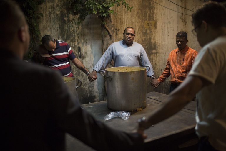In this April 11, 2014 photo, Pastor Celio Ricardo, center, prays with members of the God's Love rehabilitation center before distributing food to drug addicts at the 