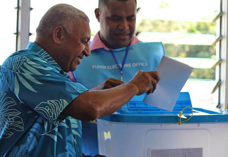 Fiji's military ruler Voreqe Bainimarama, left, casts his vote in a national election in Suva, Fiji, Wednesday, Sept. 17, 2014. Thousands of Fijians got their first chance to vote in eight years in an election that promises to finally restore democracy to the South Pacific nation of 900,000. (AP Photo/Pita Ligaiula)