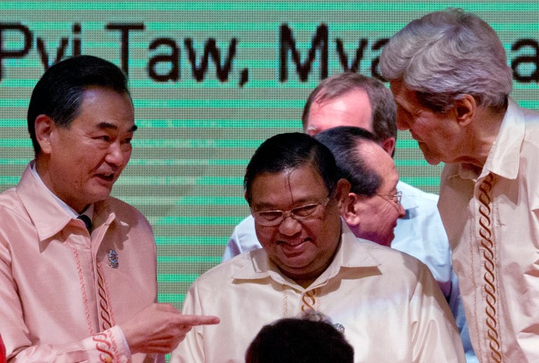 Minister of Foreign Affairs of China Wang Yi, left, gestures as Myanmar Foreign Minister Wunna Maung Lwin, center, smiles and U.S. Secretary of State John Kerry, right, watches before posing for a group picture with foreign ministers of Association of Southeast Asian Nations (ASEAN), representatives of ASEAN Regional forum, and invitees in Naypyitaw, Myanmar, Saturday, Aug 9, 2014.(AP Photo/Gemunu Amarasinghe)