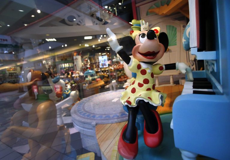 In this Friday, Jan. 31, 2014, photo, a Minnie Mouse character plays piano in a Disney Store display window in Saugus, Mass. Walt Disney Co. reports quarterly financial results after the market closes on Wednesday, Feb. 5, 2014.