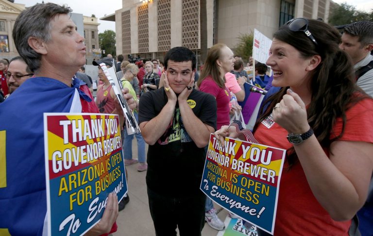 Demonstrators celebrate in different ways upon hearing that Arizona Republican Gov. Jan Brewer vetoed SB1062, at the Arizona Capitol on Wednesday in Phoenix. (AP Photo/Ross D. Franklin)