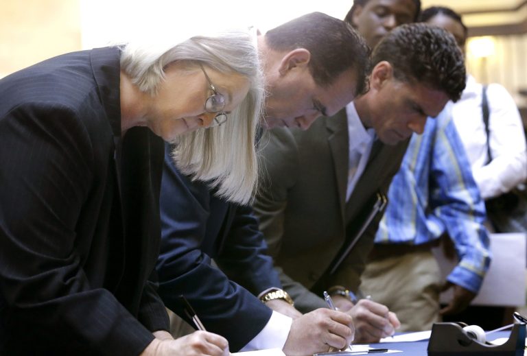 In this Wednesday, Jan. 22, 2014, photo, job seekers sign in before meeting prospective employers during a career fair at a hotel in Dallas. The government reports on state unemployment rates for December on Tuesday, Jan. 28, 2014. (AP Photo/LM Otero)