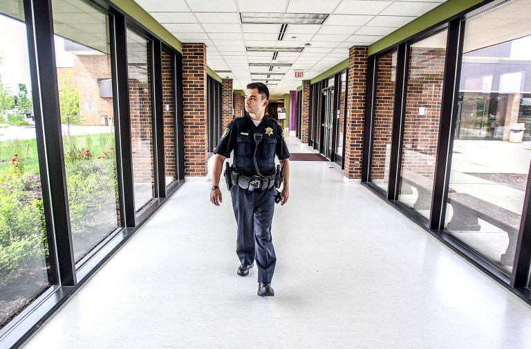 In this June 17, 2014 photo, McHenry County College police officer Marcus Pittl makes his rounds around the Crystal Lake, Ill., campus. Since transitioning from a campus safety department to a full-fledged police department in the fall of 2010, the college has simultaneously reduced costs while increasing responsiveness and services from its police operations. (AP Photo/Northwest Herald, Sarah Nader) MANDATORY CREDIT
