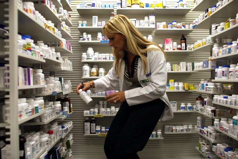 Roxana Selagea, a Publix Supermarket pharmacy manager, retrieves a bottle of antibiotics from the shelf August 7, 2007 in Miami, Florida. (Photo by Joe Raedle/Getty Images)