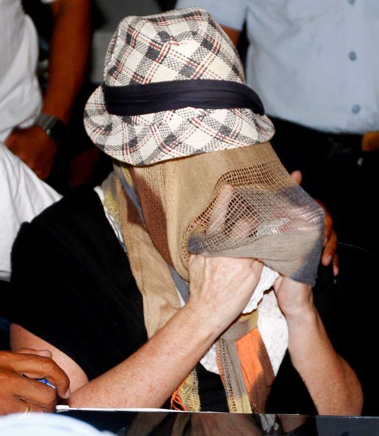 Australian Schapelle Corby, covering her face, gestures at the correctional office after she received her parole in Bali, Indonesia, Monday, Feb. 10, 2014. The Australian woman convicted of smuggling marijuana into Indonesia in 2005 has been released from jail on parole. She was convicted of smuggling 4.2 kilograms (9 pounds) of marijuana onto Bali and sentenced to 20 years in prison. (AP Photo/Firdia Lisnawati)