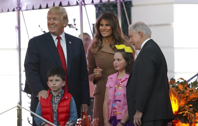 President Donald Trump and first lady Melania Trump stop to pose for photo with Attorney General Jeff Sessions' grandchildren as Trump welcomes other children from the Washington area and children of military families to trick-or-treat celebrating Halloween at the South Lawn of the White House in Washington, Monday, Oct. 30, 2017. (AP Photo/Pablo Martinez Monsivais)