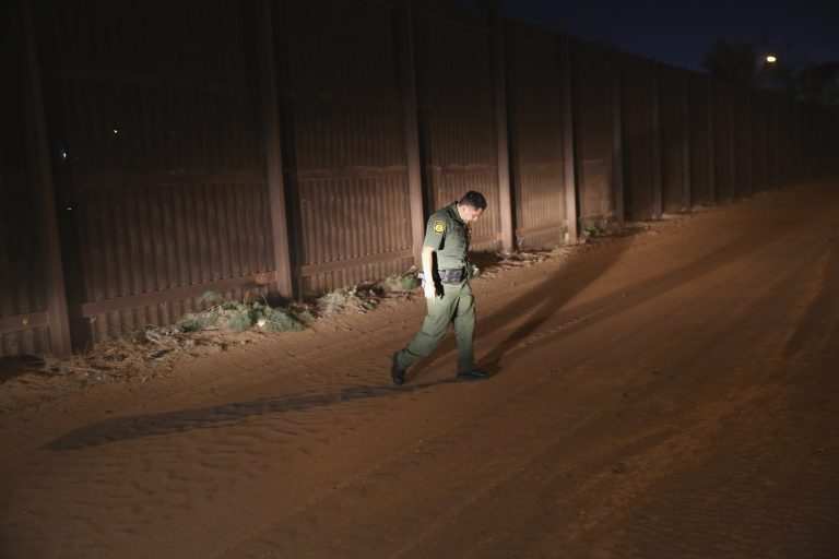 A U.S. Border Patrol agent looks for tracks along the U.S.-Mexico border fence on Nov. 15, 2013, in Calexico, California. The fence separates the large Mexican city of Mexicali with Calexico, CA, and is a frequent illegal crossing point for immigrant smugglers. (Photo by John Moore/Getty Images)