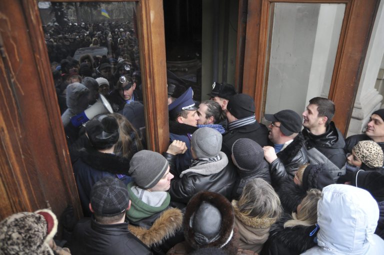 Protesters break into the building of the regional governor's office in Lviv, Western Ukraine, Thursday Jan. 23, 2014. Tensions in Ukraine spread far from its embattled capital on Thursday as hundreds of people in the city of Lviv stormed into the regional governor's office and forced him to write a letter of resignation. (AP Photo/Pavlo Palamarchuk)