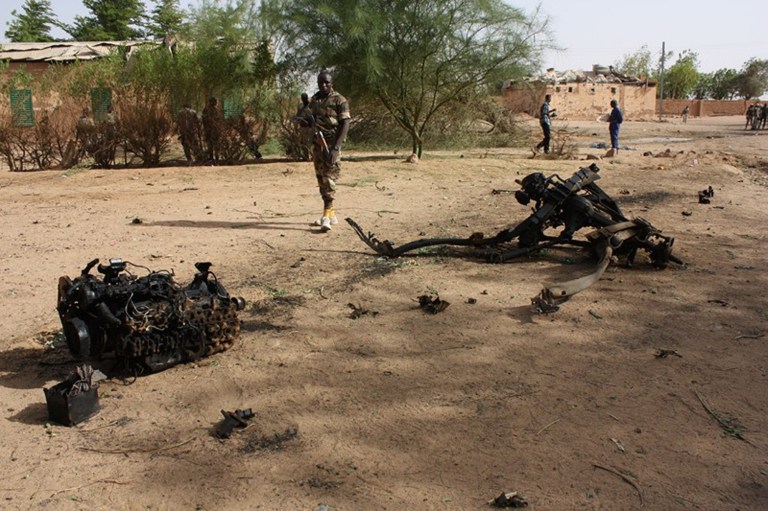 Nigerien soldiers walk near debris after suicide bombers blew themselves up inside a military barracks, in Agadez, northern Niger. A U.N. delegate said young adults in the north-central region of Africa are susceptible to joining terrorism groups due to economic hardships. (AP Photo, File)