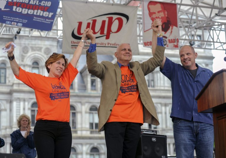 American Federation of Teachers President Randi Weingarten, left, New York State United Teachers President Dick Iannuzzi  and United Federation of Teachers President Michael Mulgrew, right, join hands during the One Voice United Rally on Saturday, June 8, in Albany, N.Y. (AP Photo/Shannon DeCelle)