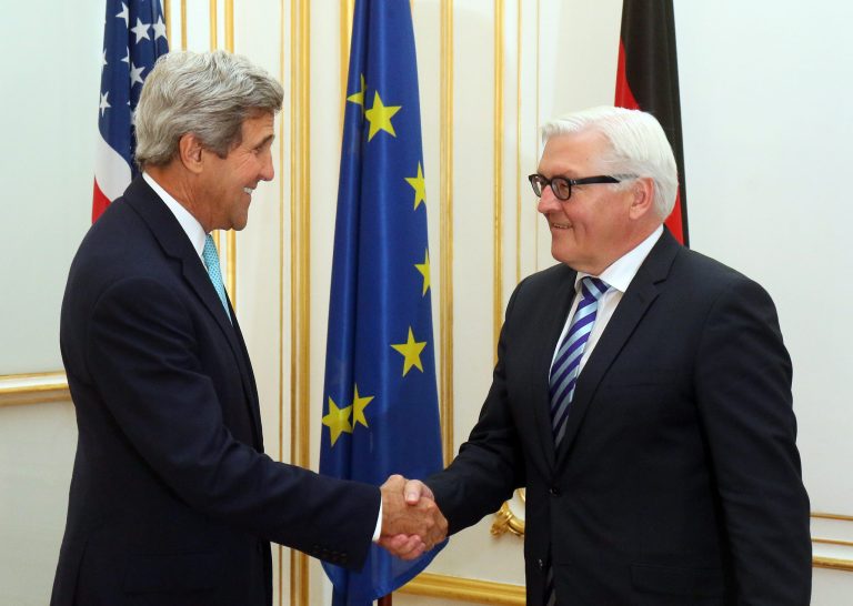 U.S. Secretary of State John Kerry, left, shakes hands with German Foreign Minister Frank-Walter Steinmeier, right, at a hotel where closed-door nuclear talks take place in Vienna, Austria, Sunday, July 13, 2014. Kerry meets separately with Steinmeier to discuss a spiraling espionage dispute between the close NATO partners. (AP Photo/Ronald Zak)
