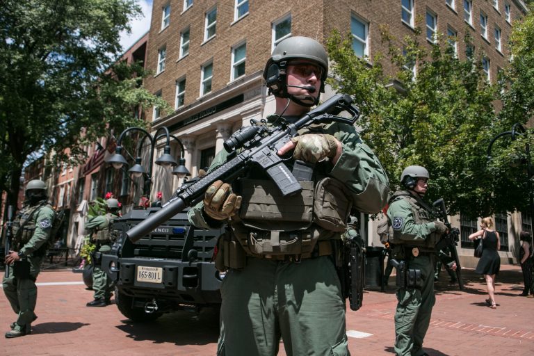 Riot police move through downtown Charlottesville, Virginia, Saturday, August 12, 2017. After clashes with anti-fascist protesters and police the rally was declared an unlawful gathering and people were forced out of Emancipation Park, where a statue of Confederate General Robert E. Lee is slated to be removed.