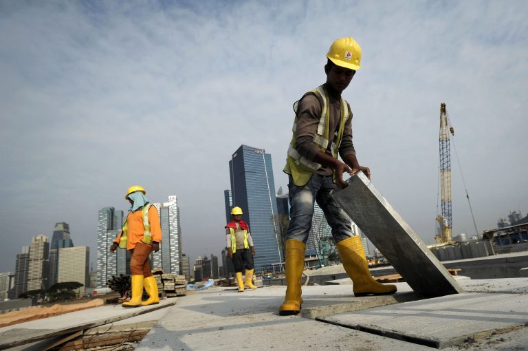 ADVANCE FOR CHRIS BRUMMIT STORY ON SINGAPORE FORCED HOME â In this photo taken Tuesday, Feb. 4, 2014, migrant workers from India construct a road leading to the Financial District, background, in Singapore.  (AP Photo/Joseph Nair)