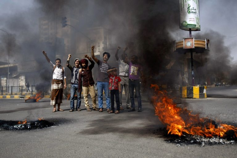 Yemenis chant slogans after setting tires on fire during a protest against the inflation of fuel prices in Sanaa, Yemen, Wednesday, July 30, 2014. Yemeni protesters blocked roads by burning tires on streets in the Yemeni capital against the government's decision to raise fuel prices. The fuel crisis which hit the country for the past several months has lead to many gas stations shutting down and cars queuing for miles at stations that still sell fuel. The crisis affected public transportation drivers mostly. (AP Photo/Hani Mohammed)