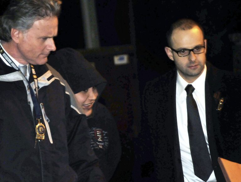   In this Saturday, Dec. 29, 2012 photo, New York City Police Department detectives escort Erika Menendez, second from left, out of the 112th Precinct in the Queens borough of New York. Menendez was arraigned Saturday night on a charge of murder as a hate crime. Judge Gia Morris has ordered that the 31-year-old be held without bail and be given a mental health exam. (AP Photo/Newsday, Danielle Finkelstein) NYC LOCALS OUT  