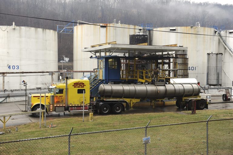 Workers pump 4-methylcyclohexane methanol, a foaming agent used in the coal preparation process, out of a 48,000-gallon tank at Freedom Industries, a chemical storage facility, in Charleston, W.Va., on Friday, Jan. 10, 2014. The White House has issued a federal disaster declaration in West Virginia, where a chemical spill that may have contaminated tap water has led officials to tell at least 300,000 people not to bathe, brush their teeth or wash their clothes. The West Virginia National Guard planned to distribute bottled drinking water to emergency services agencies in the nine affected counties. About 100,000 water customers, or 300,000 people total, were affected, state officials said. (AP Photo/Tyler Evert)