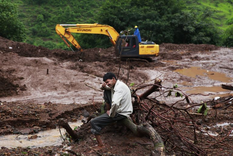 Chandrakant Zanjare, who said he lost 13 family members to a landslide, wails near the site where his house stood in Malin village, in the western Indian state of Maharashtra, Friday, Aug. 1, 2014. Heavy rains hampered efforts Friday by hundreds of rescue workers digging through heavy mud and debris, as the death toll from a landslide that engulfed an entire village in western India crossed 50. (AP Photo/Rafiq Maqbool)