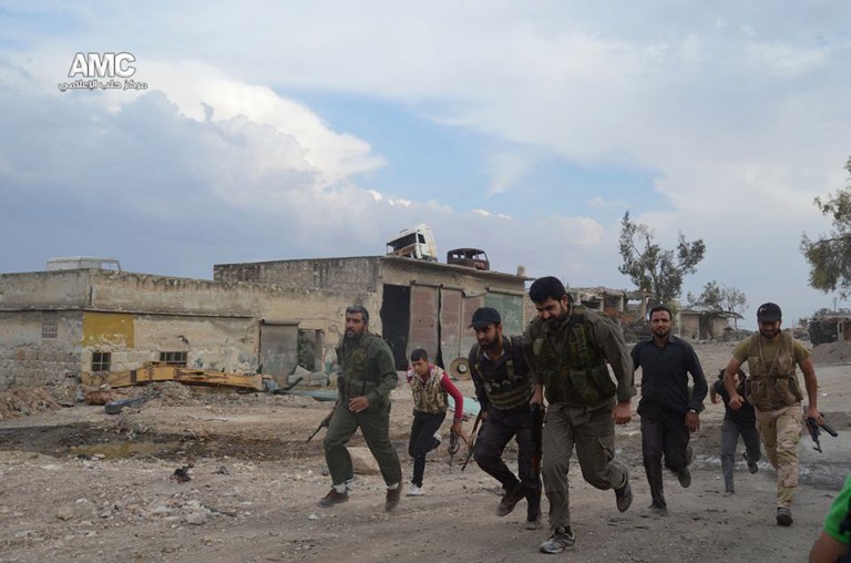 This photo provided by the anti-government activist group Aleppo Media Center (AMC), which has been authenticated based on its contents and other AP reporting, shows Free Syrian Army fighters running at one of the front lines in the town of Sheikh Najjar, in Aleppo, Syria, Tuesday June 10, 2014. (AP Photo/Aleppo Media Center, AMC)