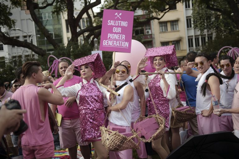 Gay activists dressed as female construction workers or Samsui Women and laborers from the colonial period, pose in mock salute on Saturday, June 28, 2014 in Singapore. Thousands of gay rights activists gathered in downtown Singapore on Saturday for a rally that this year drew unprecedented criticism from religious conservatives, with one influential Christian pastor calling on the government to ban the event.(AP Photo/Joseph Nair)