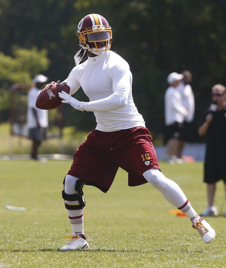Charles Dharapak/AP
Redskins quarterback Robert Griffin III can run and throw with other injured players during organized team activities this week.