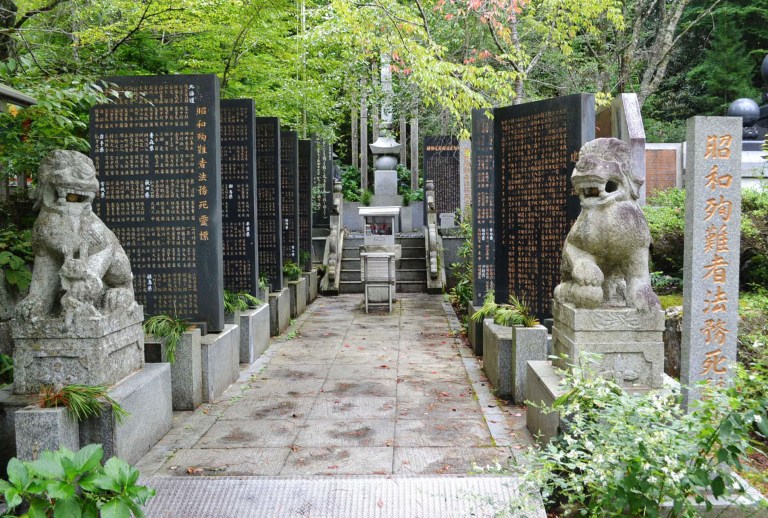 Stone-carved guardian dogs sit at the entrance of a memorial compound honoring World War II-era war criminals in Koyasan Okuno-in temple in Koya town, Wakayama prefecture, central Japan, Wednesday, Aug. 27, 2014. Japan's Chief Cabinet Secretary Yoshihide Suga acknowledged Wednesday that Prime Minister Shinzo Abe on April 29 sent a note to the Koyasan temple's ceremony honoring hundreds of war criminals that praised their contributions to the country. Suga said that Abe sent the note to the ceremony, but in his capacity as head of the ruling Liberal Democratic Party, not as prime minister. (AP Photo/Kyodo News) JAPAN OUT, CREDIT MANDATORY