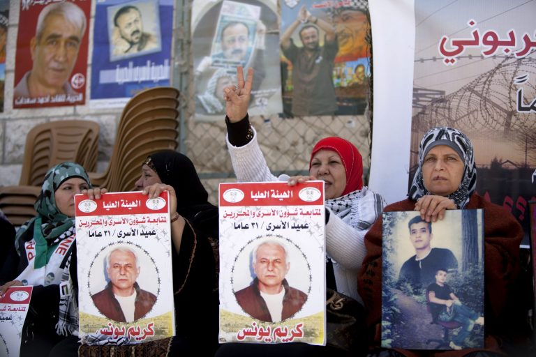Women hold portraits of Palestinian prisoners held in Israeli jails during a rally calling for their release in the West Bank city of Ramallah, Tuesday, April 1, 2014. Arabic on the posters read, 
