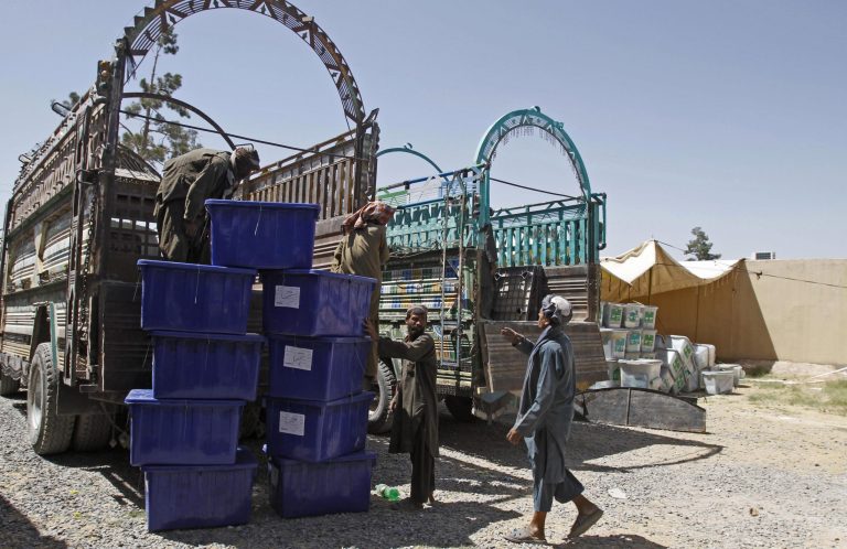 Afghan election workers load ballot boxes and election materials into trucks to deliver to polling stations, at a warehouse in Kandahar, Afghanistan, Thursday, June 12, 2014. The second round of Afghanistan's presidential election will take place on June 14, 2014. (AP Photo/Allauddin Khan)