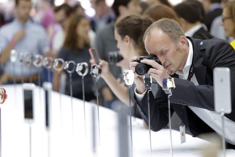 A man photographs Apple Watches during the product release announcement event on Tuesday, Sept. 9, 2014, in Cupertino, Calif. (AP Photo/Marcio Jose Sanchez)