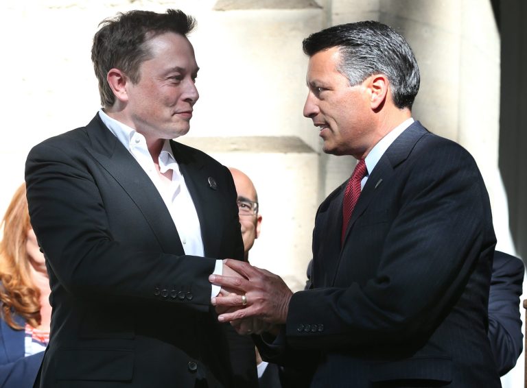 Tesla Motors CEO Elon Musk, left, and Nevada Gov. Brian Sandoval shake hands following a press conference where Nevada was announced as the new site for a $5 billion car battery gigafactory, at the Capitol in Carson City, Nev., on Thursday, Sept. 4, 2014. (AP Photo/Cathleen Allison)