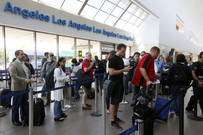 FILE - This April 22, 2013 file photo shows travelers standing in line at the LAX International Airport in Los Angeles. Under pressure, the White House signaled Wednesday it might accept legislation eliminating Federal Aviation Administration furloughs blamed for lengthy flight delays for airline passengers, while leaving the rest of $85 billion in across-the-board spending cuts in place. (AP Photo/Damian Dovarganes, File)