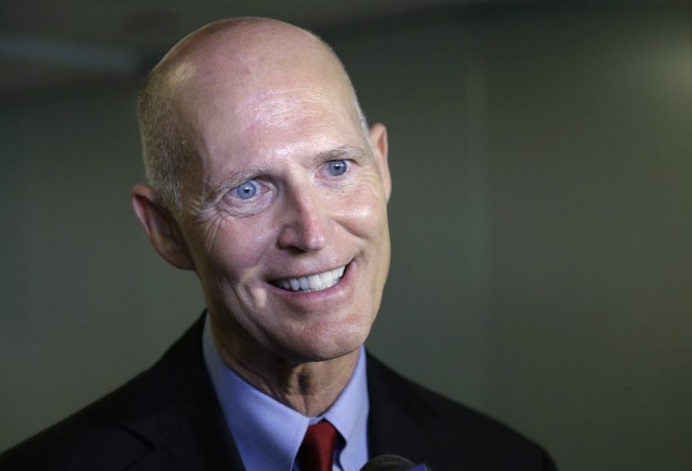 In this Sept. 22, 2014 photo, Florida Gov. Rick Scott speaks with members of the media in Miami. If former Florida Gov. Charlie Crist gets his old job back, he promises to expand Medicaid to roughly 1 million low-income residents by calling a special Legislative session or an executive order. If Gov. Rick Scott is re-elected, the decision will be once again left to the Legislature with little meddling from him. The Sunshine State has one of the highest uninsured rates in the country. (AP Photo/Wilfredo Lee)
