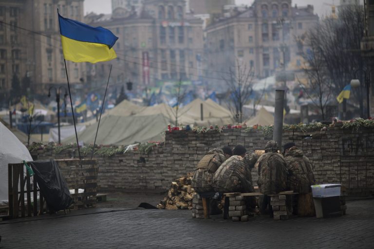Anti-Yanukovych protesters warm themselves next to a fire in Kiev's Independence Square, Ukraine, on Wednesday. (AP/Emilio Morenatti)
